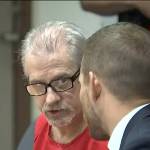 Photo via broadcast video feed.
Patrick Nicholas, left, consults with defense attorney David Montes on May 25 at the Maleng Regional Justice Center in Kent.