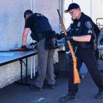 A Kent Police officer carries a gun returned during the June 3 buyback at the Kent Police/Fire Training Center on the East Hill. COURTESY PHOTO, Zandria Michaud, Kent Police