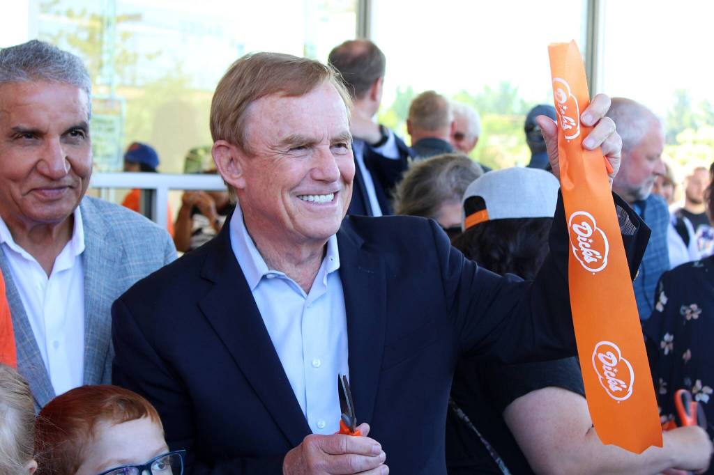 King County Councilmember Pete von Reichbauer holds a piece of the tape during the ribbon cutting for the new Federal Way Dicks Drive-In. This is a family operation committed to the local community, von Reichbauer said. (Alex Bruell / The Mirror)