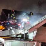 Firefighters scramble up a ladder truck to combat a fire at a vacant Kent home. COURTESY PHOTO, Puget Sound Fire
