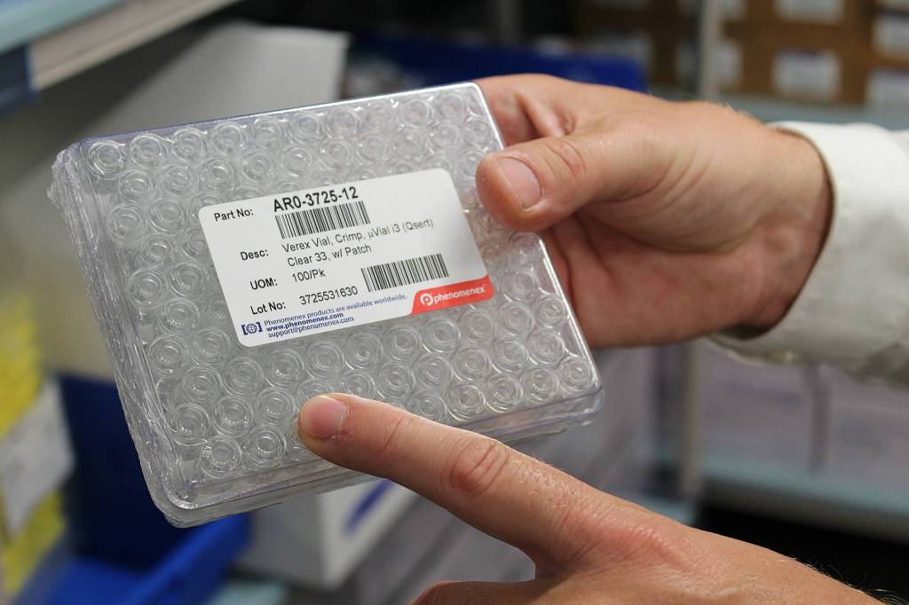 Photo by Alex Bruell / The Mirror
After many steps of processing and extracting a sample sent to the lab, the actual drug sample tested by the toxicology lab machines is often as small as one of these vials, which Federal Way toxicology lab manager Brian Capron points to in this picture.