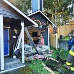 Firefighters examine the damage to a Kent home Oct. 6 after a car crashed into it. COURTESY PHOTO, Puget Sound Fire