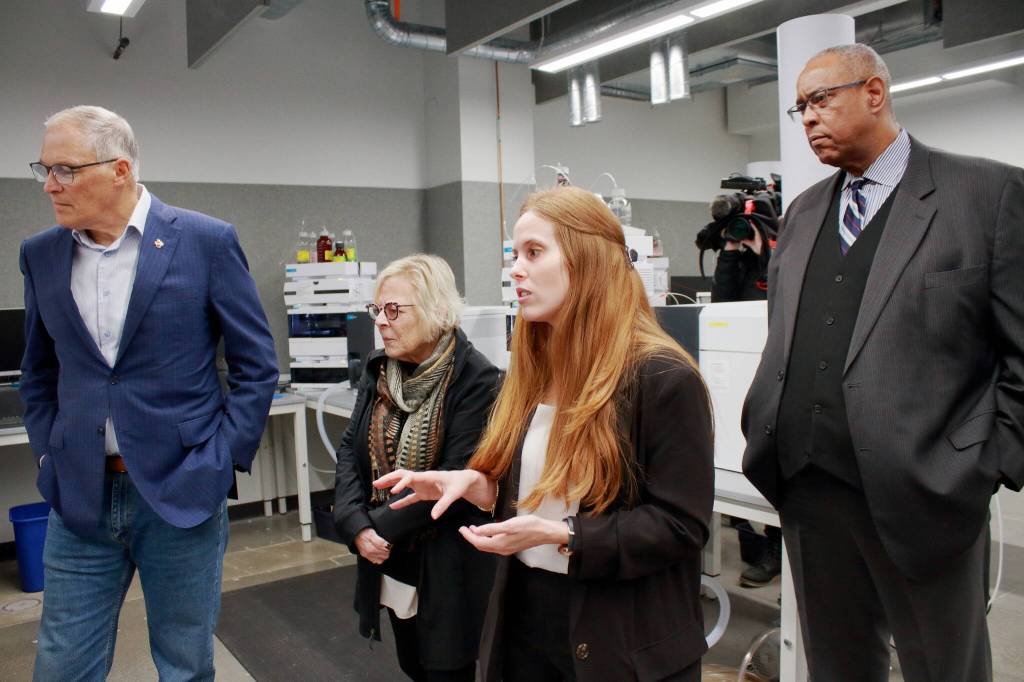 Technical lead Madison Fuller shows the toxicology labs new equipement to Gov. Jay Inslee, State Sen. Claire Wilson and John Batiste. Fuller will take on a new role as quality assurance manager in January. Photo by Keelin Everly-Lang / The Reporter