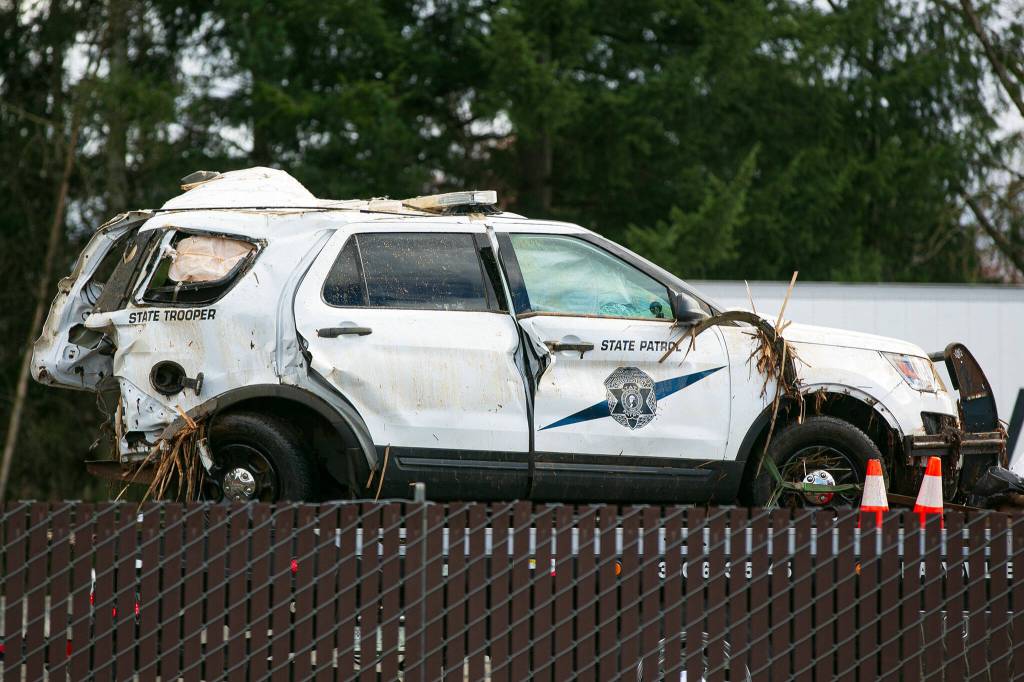 A heavily damaged Washington State Patrol vehicle is hauled away after a crash killed a trooper on southbound I-5 overnight Saturday, March 2, 2024, in Marysville, Washington. (Ryan Berry / The Herald)