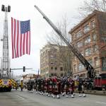 Bagpipes and drums lead a procession down Hewitt Avenue during a memorial for Washington State Trooper Chris Gadd on Tuesday, March 12, 2024, outside Angel of the Winds Arena in Everett, Washington. (Ryan Berry / The Herald)