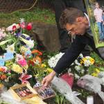 Chase Wilcoxson, father to Matilda, 13, and Eloise,12, places a family photo at the roadside memorial dedicated to his daughters, Buster Brown, 12, and Andrea Hudson, 38. Photo by Bailey Jo Josie/Sound Publishing.