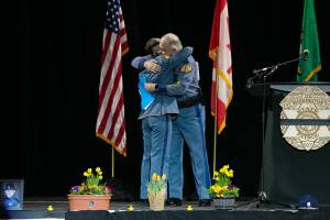 Captain Ron Mead and Corporal Alexis Robinson embrace during a memorial for Washington State Patrol trooper Chris Gadd on Tuesday, March 12 at Angel of the Winds Arena in Everett, Washington. (Ryan Berry / Sound Publishing)