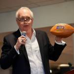 Steve Raible auctioning off a Seahawks football from 1983.