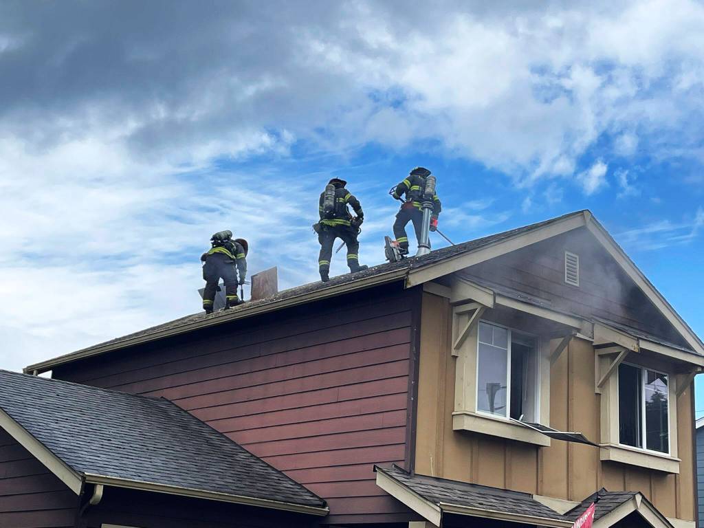 Puget Sound Fire firefighters take to the roof to combat a house fire Monday afternoon in Kent in the 23400 block of 134th Court SE. COURTESY PHOTO, Puget Sound Fire