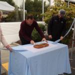 Top Pot Doughnuts CEO Jim Eschweiler cuts a maple bar to mark the beginning of a new facility in Kent. COURTESY PHOTO, City of Kent