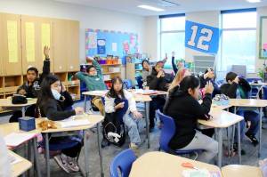 Students raise their hands to indicate that they participated in breakfast that morning during attendance. Each class tracks meals a different way, finding how best to seamlessly integrate it into their usual morning activities. Photo by Keelin Everly-Lang / the Mirror.