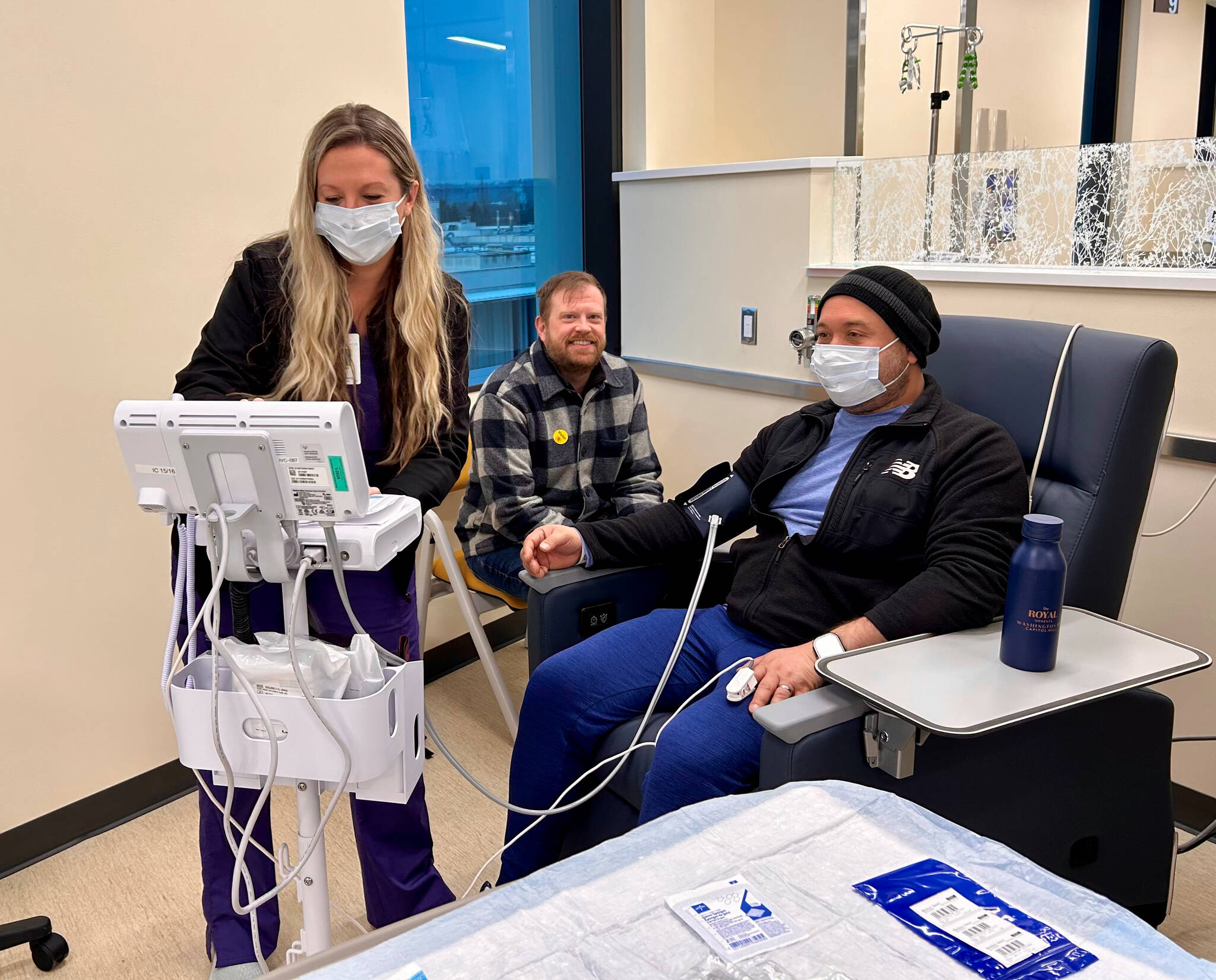 Samuel Martinez Santamaria (right) was one of the first patients to receive treatment at the new Cancer Center. He was attended by Licensed Practical Nurse (LPN) Leigha Baker (left) and supported by his husband Alex Shockey (center), who is also a Valley Medical Center employee. Photo courtesy of Valley Medical Center.