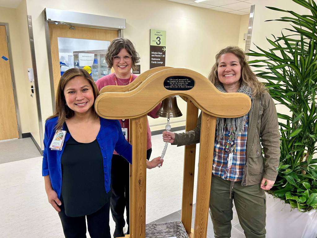 (Left to right) Infusion Center Manager Chermaine Wulff, Director of Philanthropy & Volunteer Services Carrie Murayama and Chief Communications & Philanthropy Officer Liz Nolan showcase the new Cancer Centers Cancer Bell, which will be rung by cancer patients to mark the end of their treatment. The inscription on the bell says, Life is not measured by the number of breaths we take, but by the moments that take our breath away. Smile - this is one of those moments! Photo courtesy of Valley Medical Center.