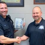 City of Kent Corrections Officer Travis Reed, left, receives recognition in 2019 for 20 years on the job from Police Chief Rafael Padilla. Reed is on administrative leave, under investigation for alleged misconduct while on duty. FILE PHOTO, City of Kent