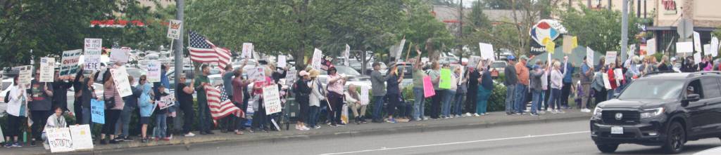 People wave signs in Covington and many drivers honk their horns in support. STEVE HUNTER, Kent Reporter