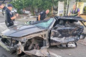 Kent Police officers examine a black 2013 Chevrolet Camaro after it crashed July 7 into a day care facility along East Smith Street. COURTESY PHOTO, Puget Sound Fire