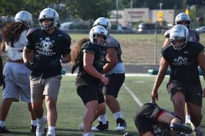 Kentwood linebacker gives a smile during team drills at Kentwood football practice. Ben Ray / The Reporter