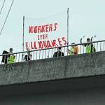 People display a banner Sept. 1 on an overpass above State Route 18 in Covington. COURTESY PHOTO, Indivisible Covington WA