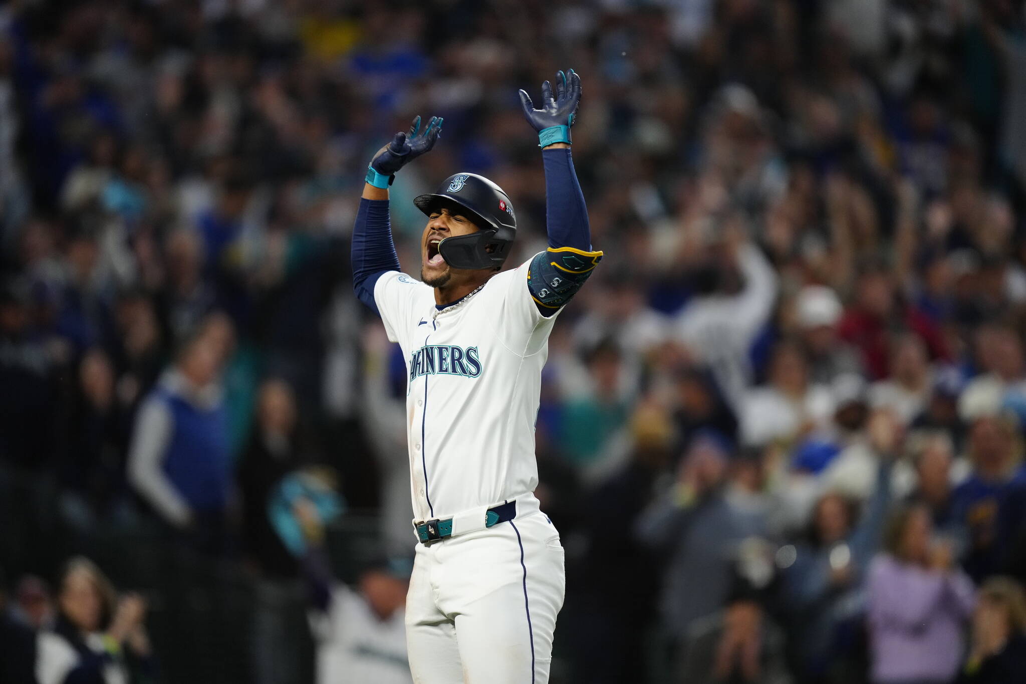 Julio Rodriguez raises his arms after scoring on a home run. Photo credit: Ben Van Houten / Seattle Mariners