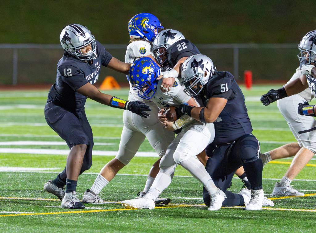 Kentwood defenders wrap up Brady Bonnell of Tahoma. Photo by Robby Mullikin