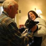 Weatherly Inn general manager Sabrina Selden holds Milo the house dog in-training so that a resident can give him some pets. Photo by Bailey Jo Josie/Sound Publishing.