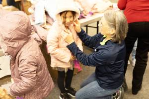 tA student gets fitted with a new coat at Springbrook Elementary School in Kent, part of a donation program by the Knights of Columbus. COURTESY PHOTO, Kent School District