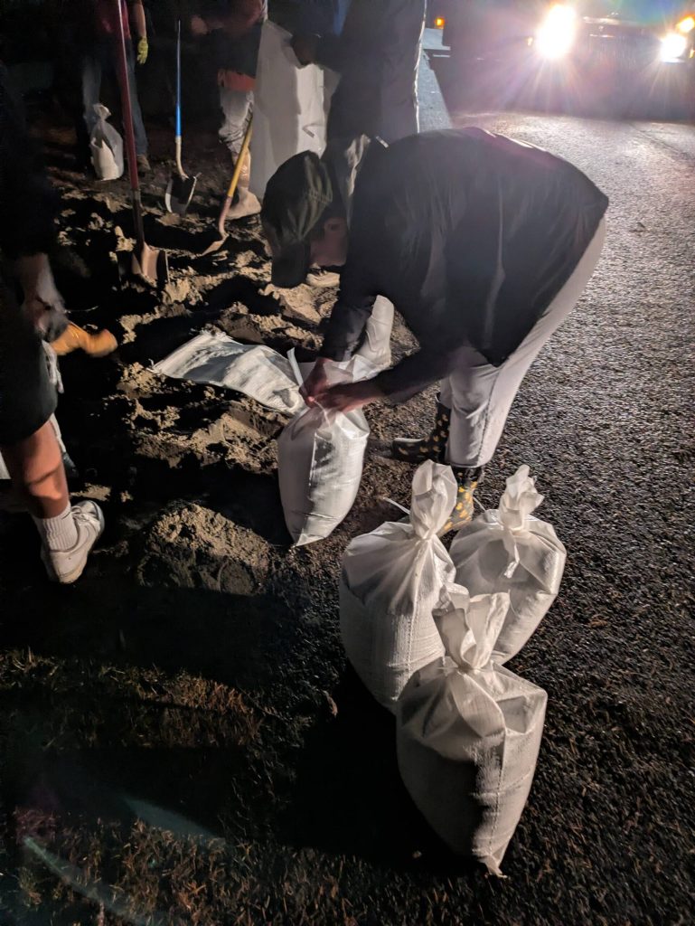Taken at 5:16 p.m. on Thursday night, Maplewood neighbors work into the night to create sandbags to keep the Cedar River from flooding homes. The neighbors had paid Burien Bark to deliver the sand, which they hand-bagged. Photo by Bailey Jo Josie/Sound Publishing.