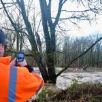 King County Flood Patrol member Seth Ballhorn photographs a tree as it floats down the Snoqualmie River during flooding Dec. 9, 2025. (Grace Gorenflo/Sound Publishing)