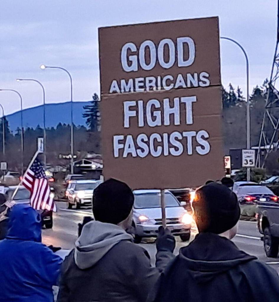 Demonstrators let drivers in Covington know what they think. COURTESY PHOTO, Indivisible Covington