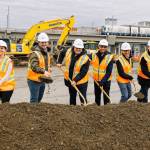 The Sound Transit transit oriented development team breaks ground on the Kent Multicultural Village construction site March 18 with the light rail platform of Kent Des Moines Station in the background. From left to right: Rennie Elliott, Jordan Rash, Heather Burns, Curvie Hawkins, Tim Bates and Marshall Foster. COURTESY PHOTO, Sound Transit