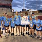 Kentwood runners stand with Washington sign.