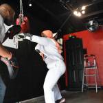 Kelley trains with a young boxer using new pads. Ben Ray / The Reporter