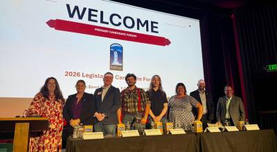 SnoValley Chamber of Commerce CEO Kelly Coughlin Games stands with candidates at a forum hosted by the chamber July 14, 2026. From left: Coughlin Games; Michelle Bennett; Zach Hall; Topher Leritz; Aimee Warmerdam; Maggie Adams; Adam James; Mike Steele. (Grace Gorenflo/Valley Record)